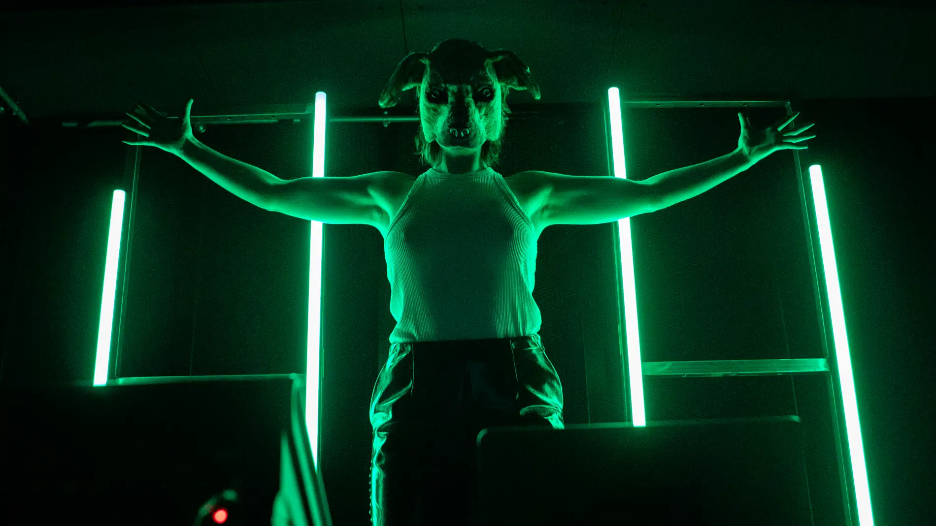 En skuespiller står på en scene i grøn belysning