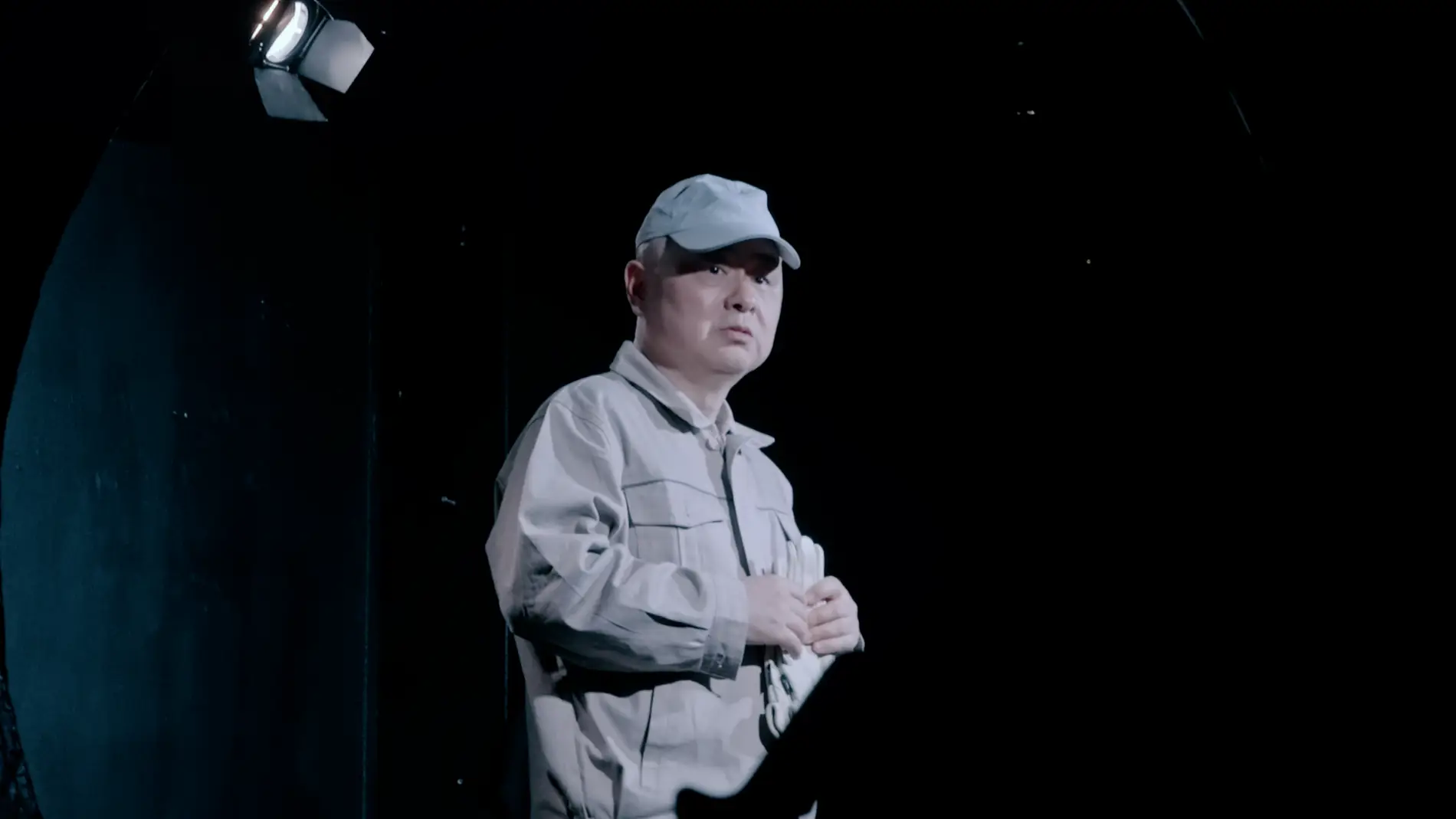 En kinesisk mand sidder på en scene